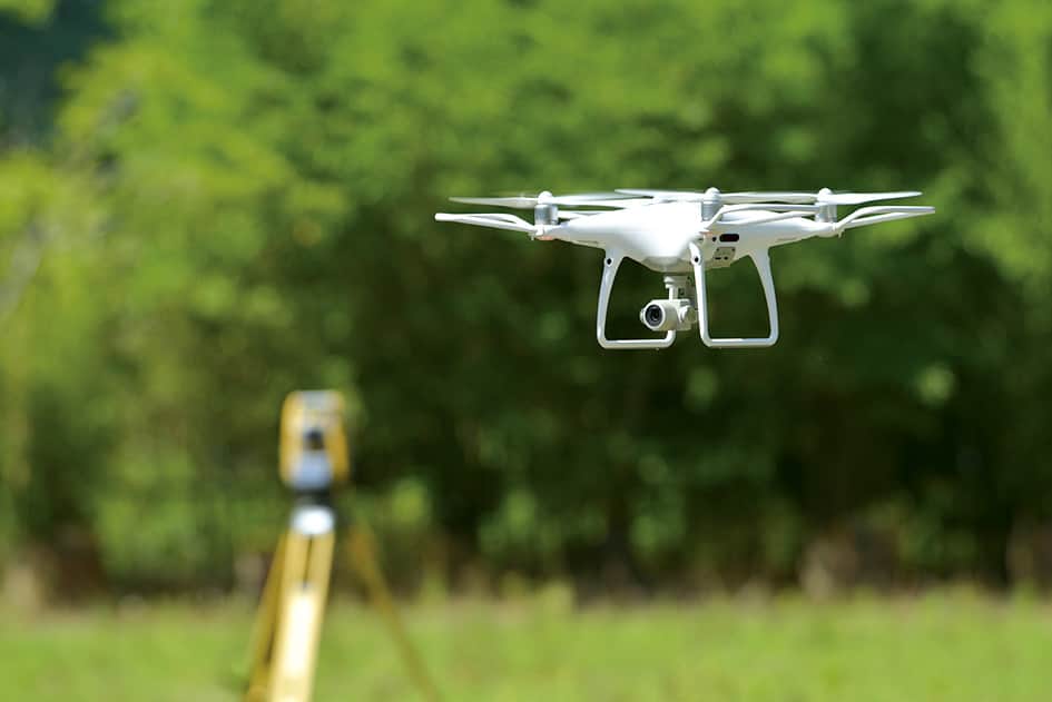 測量現場で飛行する白いドローン